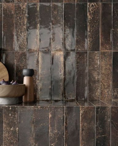 Carreaux sombres avec des reflets, accompagnés d'un plat et de contenants en métal.