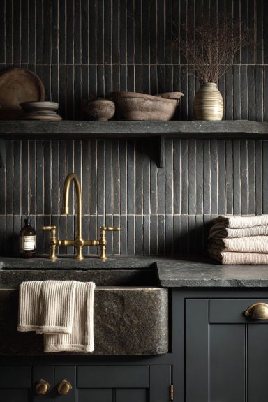 Cuisine moderne avec évier en métal, robinet doré et étagères en bois. Tissus et décor minimalistes.